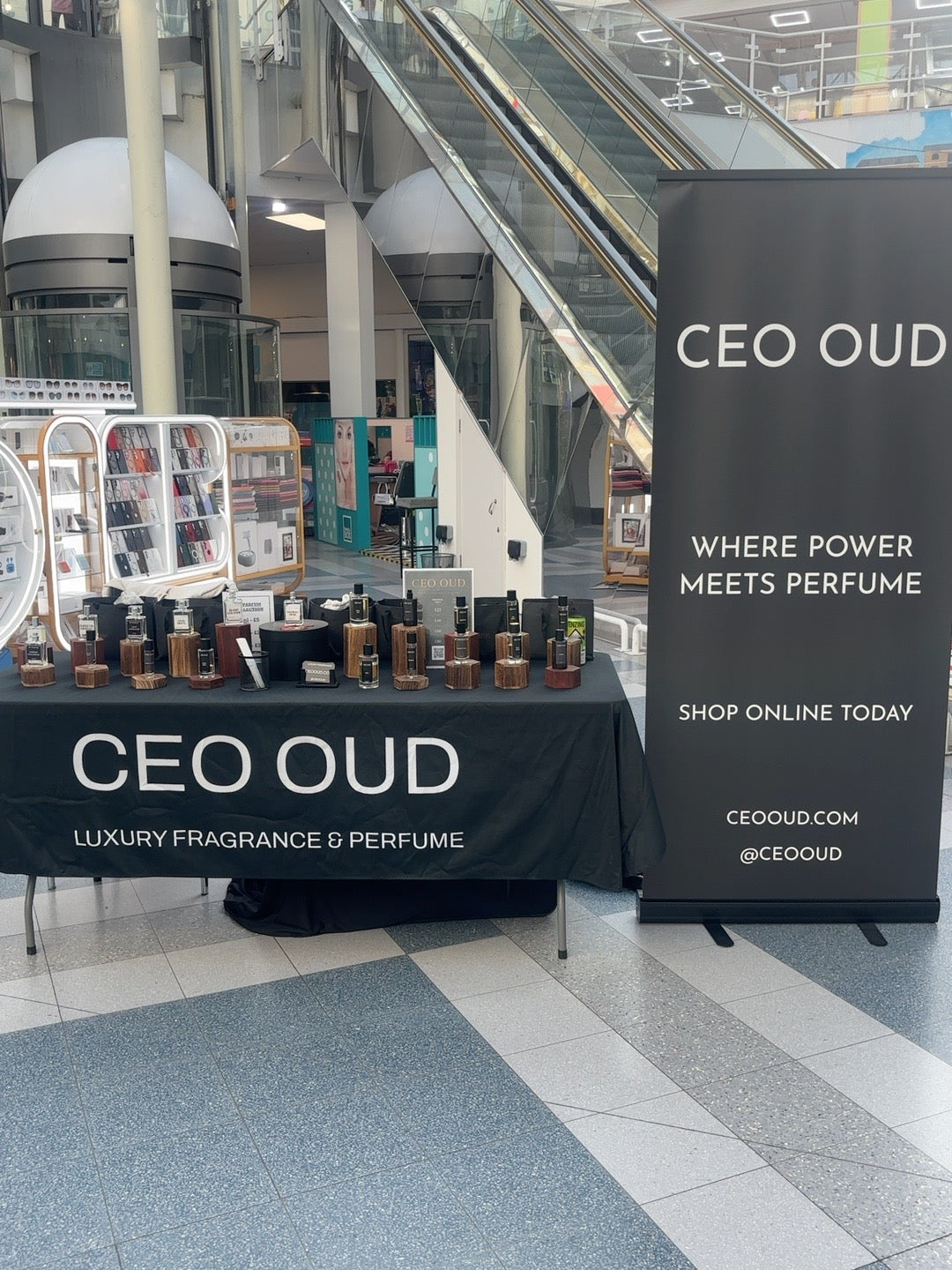 CEO OUD perfume display and branded banner beside the shopping centre escalators