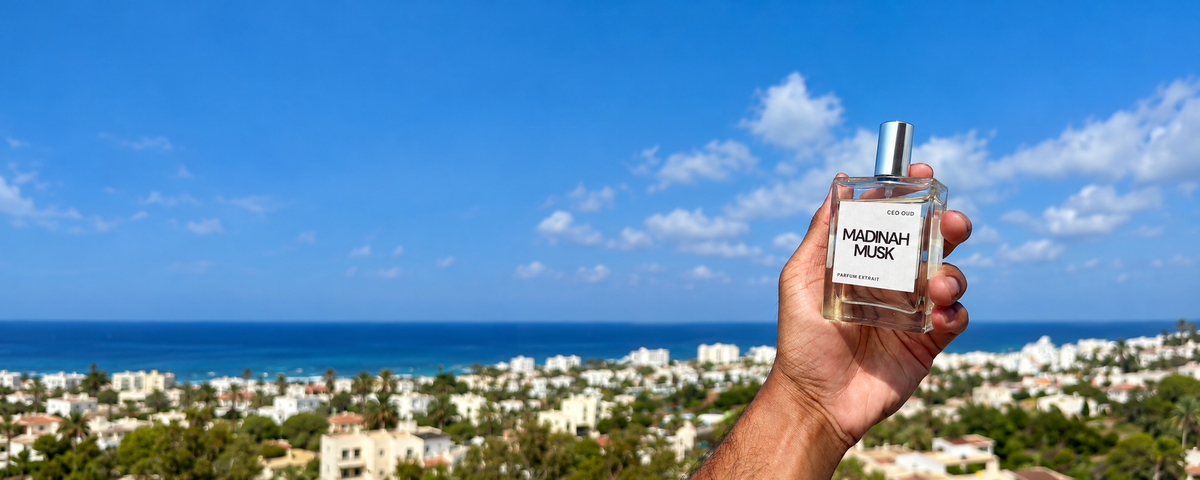Madinah Musk held in sunlight overlooking a coastal town and blue sea